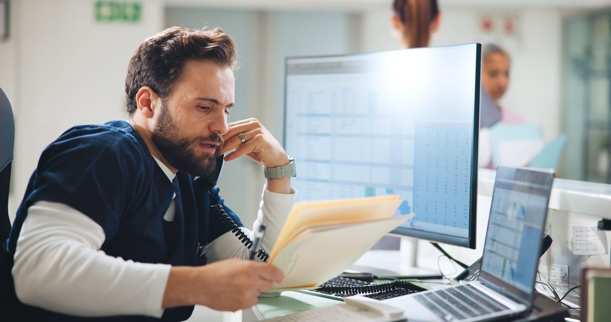 Medical office staff coordinating patient records by phone