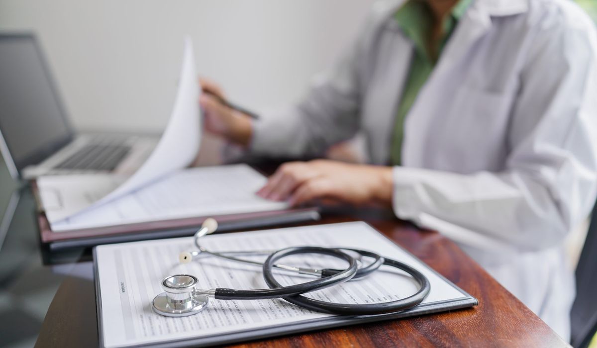Physician reviewing patient test results at a desk